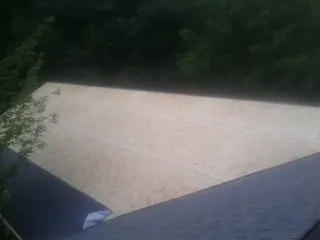 New OSB roof sheathing installed beside an existing shingle roof in Elgin